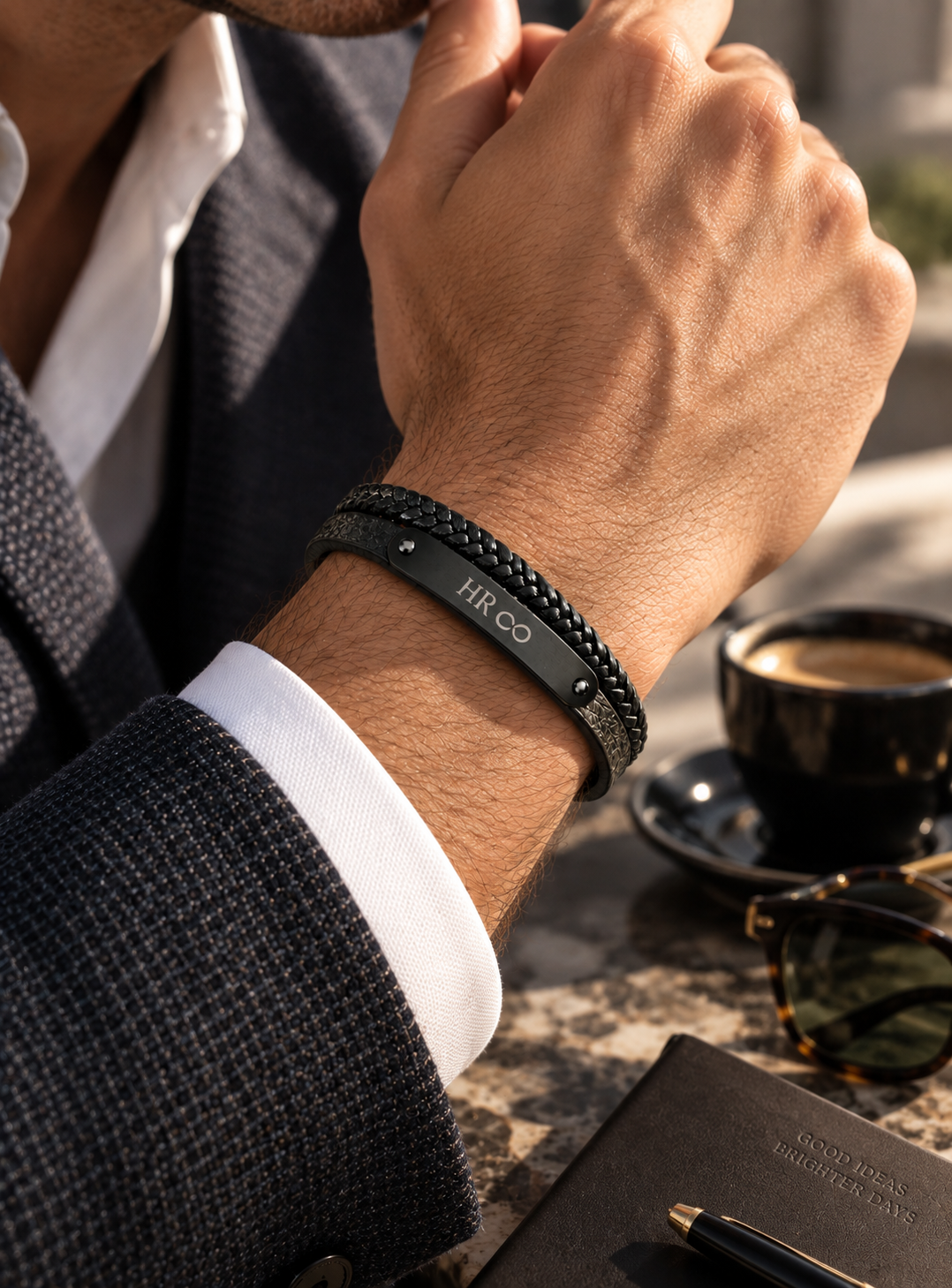 Bracelet homme cuir noir tressé et plaque acier noir gravée porté avec veste de costume