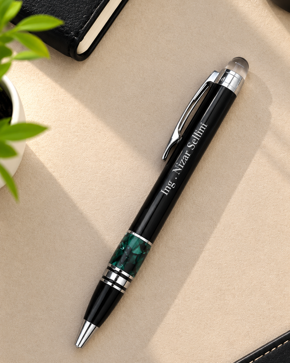 Stylo bille haut de gamme noir et vert émeraude personnalisable posé sur un bureau moderne
