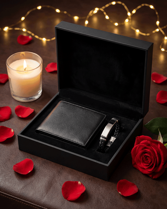 Coffret cadeau noir ouvert contenant un portefeuille en cuir noir et un bracelet tressé, entouré de pétales de roses et d'une bougie.