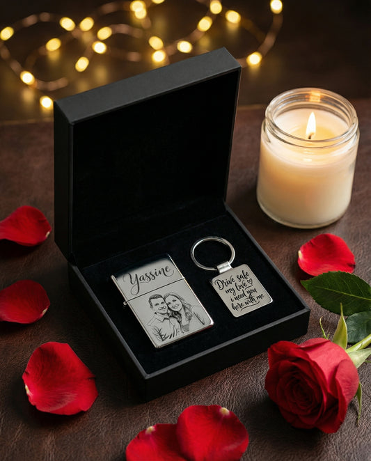 Coffret cadeau noir contenant un briquet gravé avec une photo et un porte-clé avec message romantique, entouré de pétales de roses.